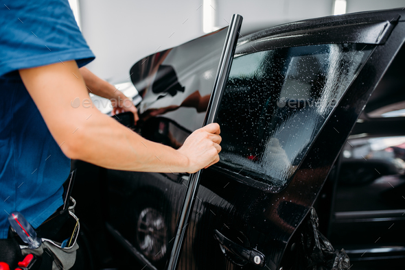 Male specialist applying car tinting film - Stock Photo - Images