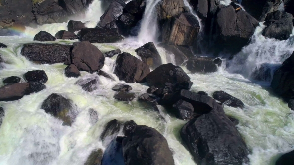 Aerial Shot of Splash Water of Waterfall with Rocks. Flowing Water.
