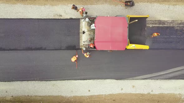 Aerial View of New Road Construction with Workers and Asphalt Laying Machinery at Work alt