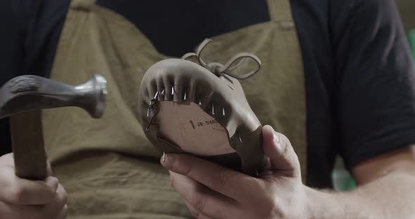 Close Up View of Tailor Nailing and Fixing Blank for Shoes in Private Leather Craftshop with Pliers