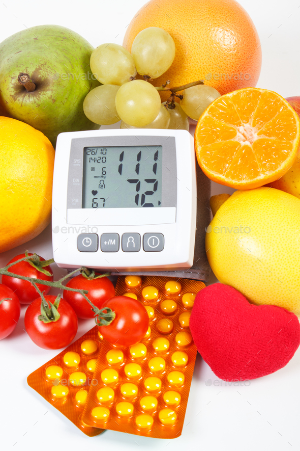 Blood pressure monitor, fruits with vegetables and medical pills Stock Photo by ratmaner