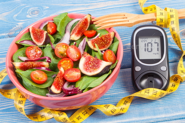 Fruit and vegetable salad and glucometer with tape measure - Stock Photo - Images
