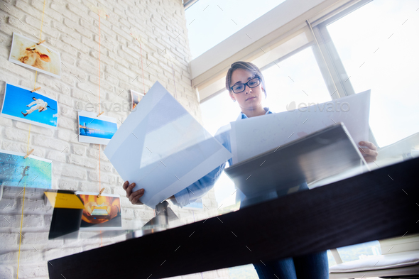 Professional Photographer Looking At Prints And Choosing Picture - Stock Photo - Images