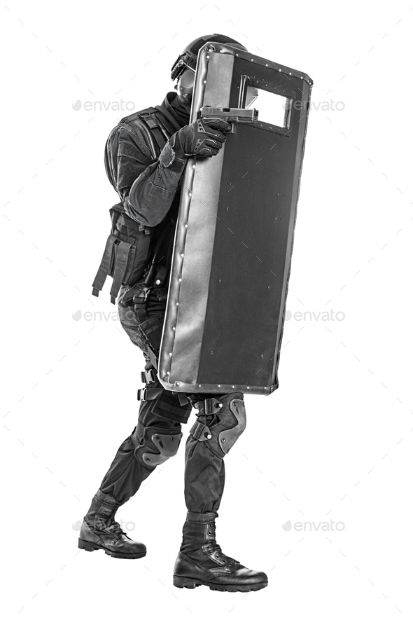 Studio shot of SWAT police special forces with pistol hiding