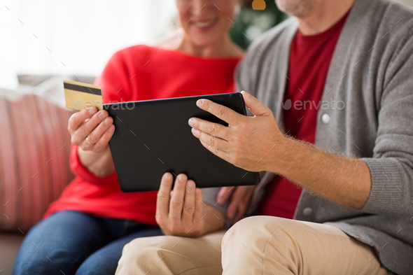 senior couple with tablet pc shopping online