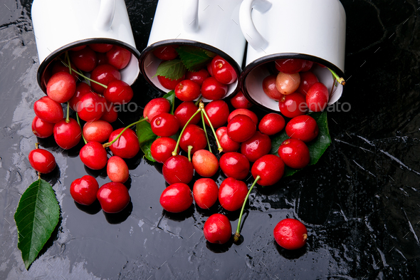 Scattered cherry from enamel cups. - Stock Photo - Images