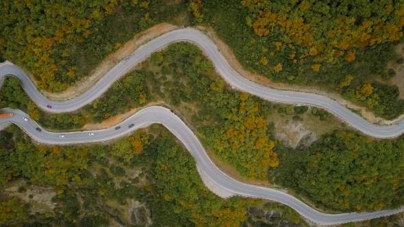 Aerial View of a Traffic Driving Along a Mountain Road in Greece alt