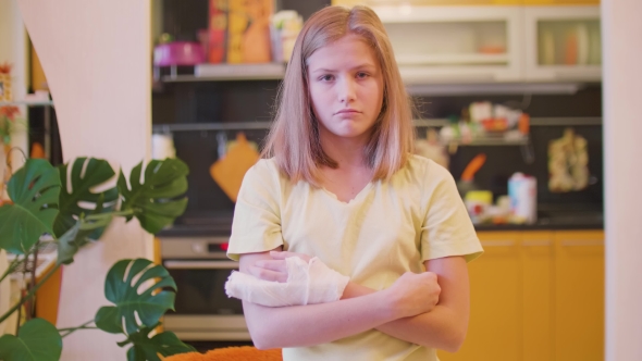 Frustrated Young Caucasian Blonde with Broken Left Hand Looking at Camera