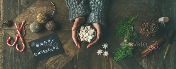 Flat-lay of greeting card, woman's hands holding mug, pine cone - Stock Photo - Images