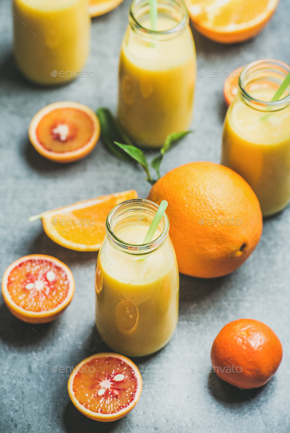 Healthy yellow smoothie in bottle over concrete background - Stock Photo - Images