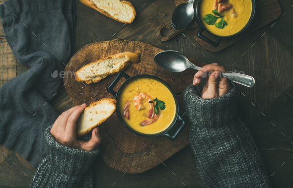 Woman in sweater eating corn soup with prawns, top view - Stock Photo - Images