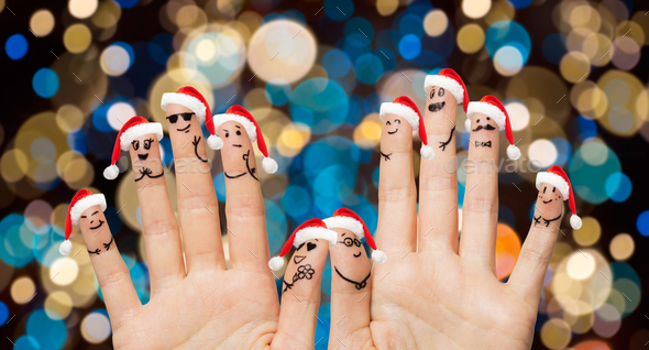hands and fingers in santa hats at christmas