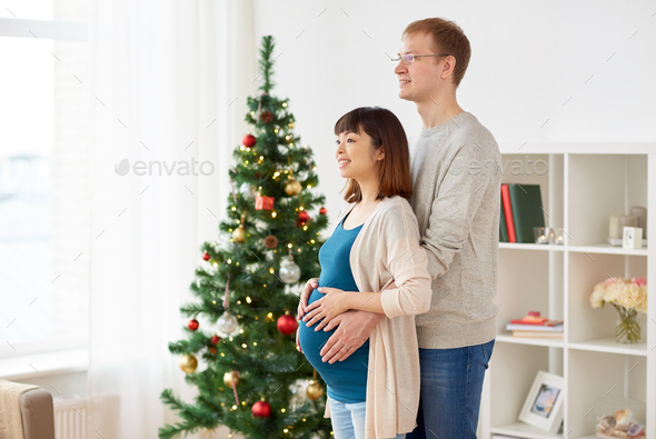 pregnant wife with husband at home at christmas