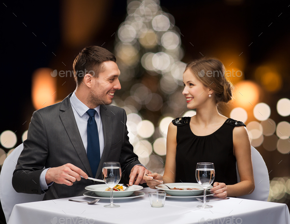 smiling couple eating at christmas restaurant