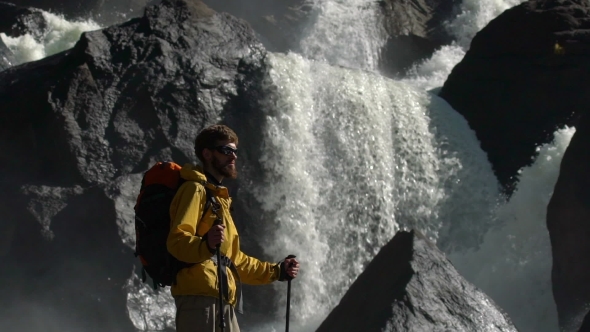 A Male Backpacker Watches a Waterfall in .