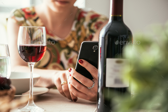 Woman using a wine app at the restaurant