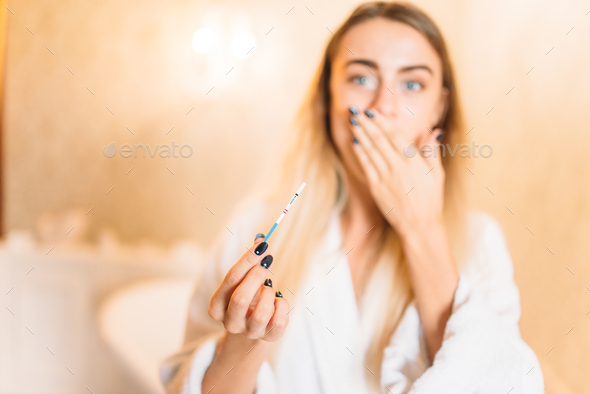 Frightened woman with positive pregnancy test - Stock Photo - Images