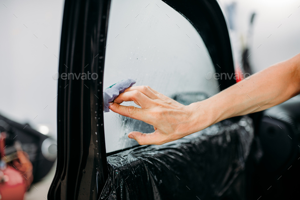 Specialist with drier, tinting film installation - Stock Photo - Images
