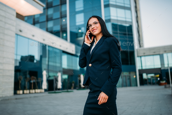 Businesswoman in suit talks by phone outdoor - Stock Photo - Images