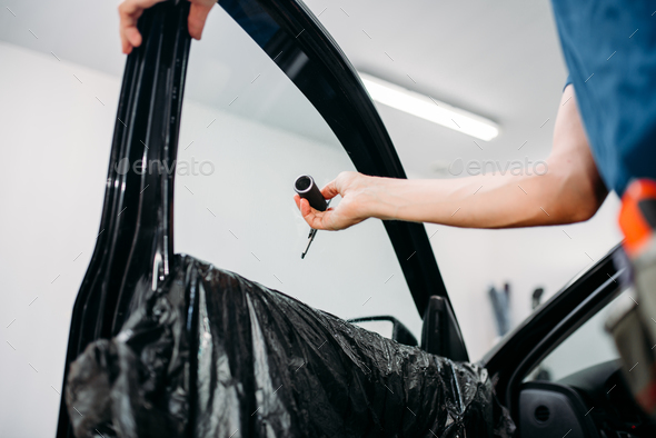 Specialist with drier, tinting film installation - Stock Photo - Images