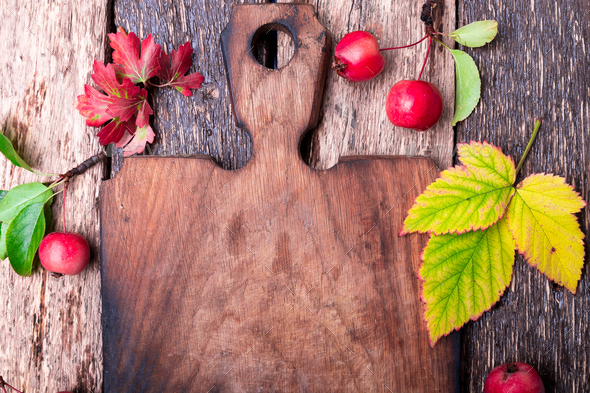 Leaves and small apple around empty cutting board - Stock Photo - Images