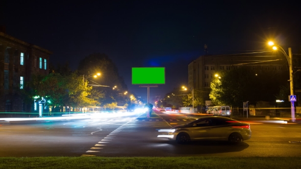 A Billboard with a Green Screen on a Background of City Traffic with Long Exposure. .