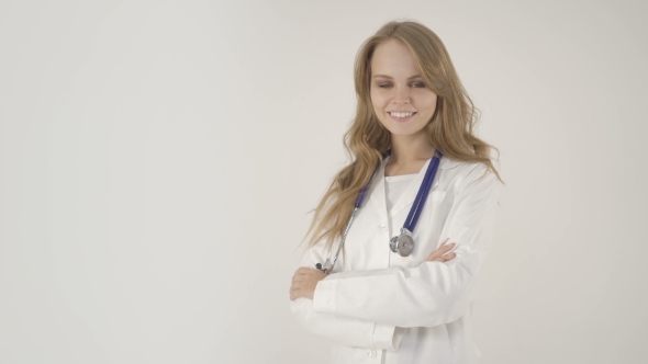 Young Smiling Female Doctor with Arms Crossed on White Background