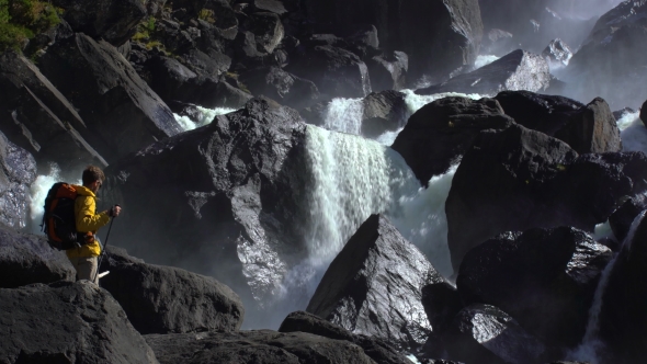 Footage of a Tourist Approaching To a Rocky Watertfall alt