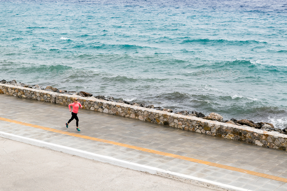 Woman running on city street at seaside