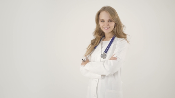 Beautiful Female Doctor in White Coat Looking at Camera and Smiling While Standing with Crossed Arms