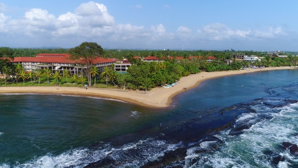Aerival View in Motion of the Hotel Near the Sandy Beach and Light Waves at the Resort in Sri Lanka