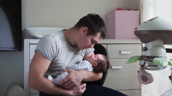 Father Holds Newborn Baby in Arms