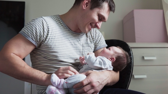 Father Holds Newborn Baby in Arms