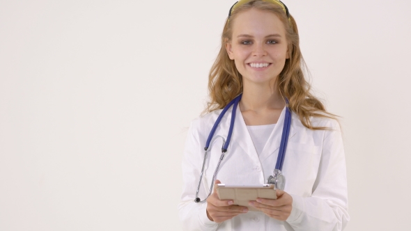 Smiling Woman Doctor with Stethoscope and Tablet for Notes in Her Hand