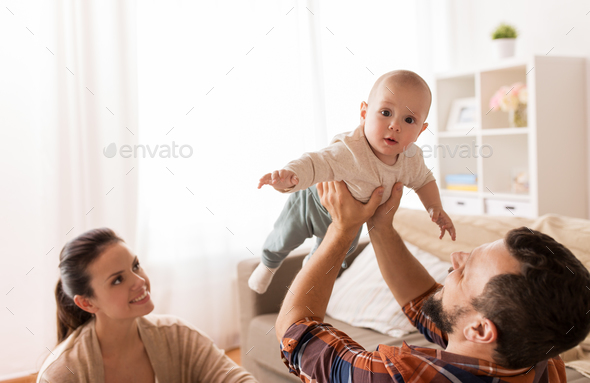 happy mother and father playing with baby at home