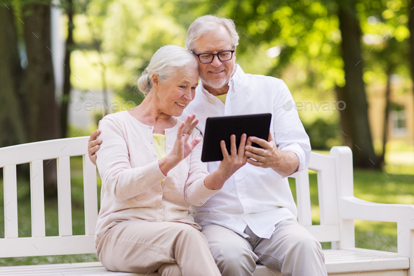 senior couple with video chat on tablet pc at park