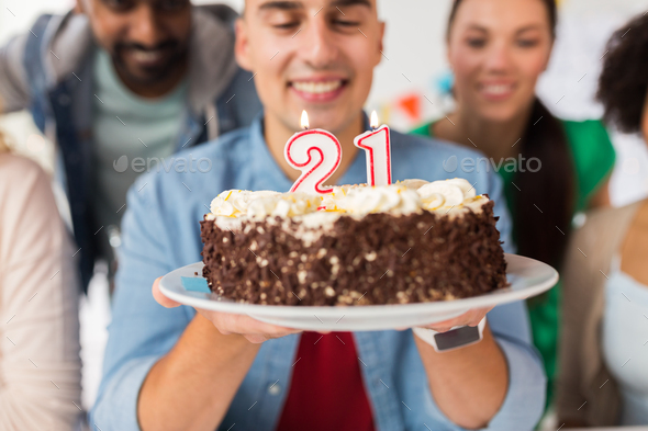 man with cake and friends at birthday party