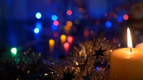 New Year's Candles, and Christmas Decorations Blurred Background with Colored Lights