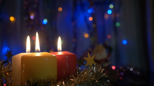 New Year's Candles, and Christmas Decorations Blurred Background with Colored Lights