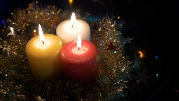 New Year's Candles and Christmas Decorations Blurred Background with Colored Lights
