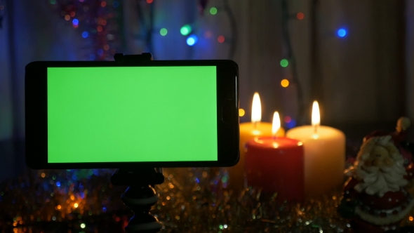 New Year's Background, in the Foreground a Smartphone with a Green Screen