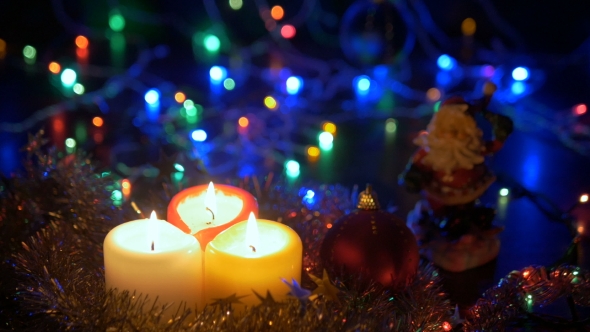 New Year's Candles and Christmas Decorations Blurred Background with Colored Lights. alt