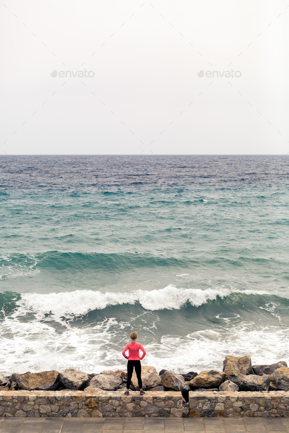 Runner on city street looking at inspiring sea view - Stock Photo - Images