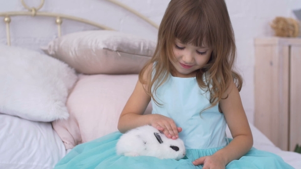 Pretty Teen Girl Having Fun, Hugging and Playing with Decorative Rabbit