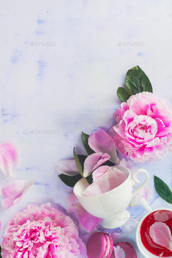 Minimal styled flat lay with peony flowers, petals and white coffee cup on a pastel background