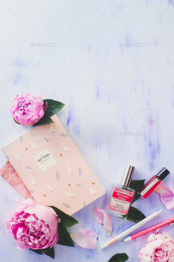Minimal styled flat lay with peony flowers, petals, stationery and notebooks on a white background
