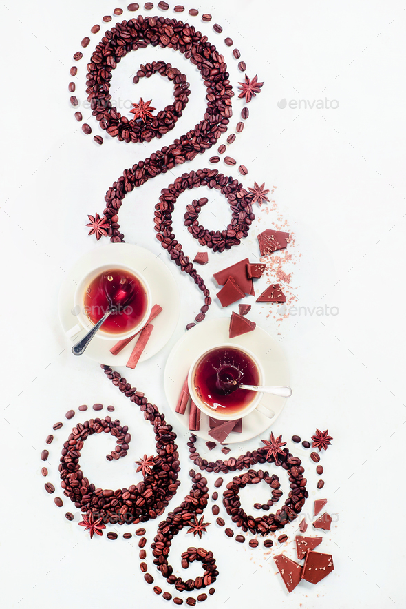 Coffee grains lying in the shape of a swirl with the cup, cinnamon, anise stars, chocolate