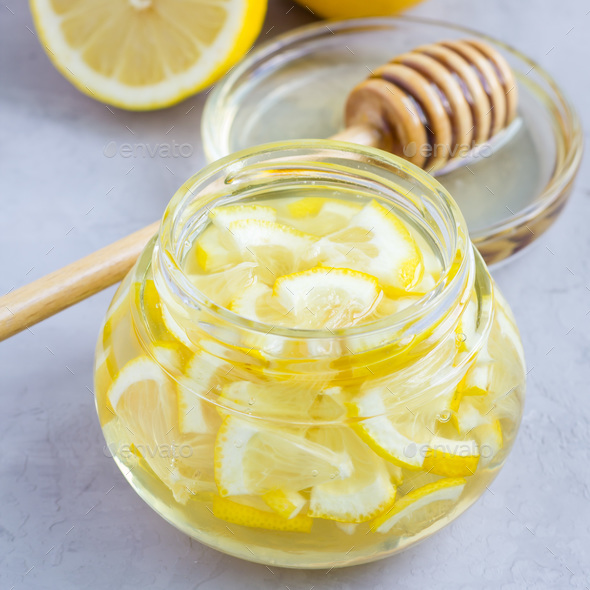 Lemon and honey mix for citrus tea in glass jar, ingredients on background, square format