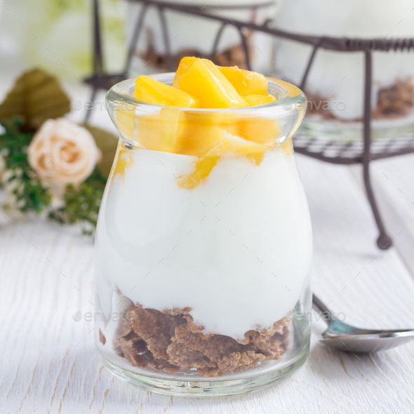 Breakfast dessert with bran flakes, plain yogurt and mango, square
