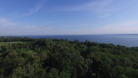 Aerial Drone Flight Footage above Calm Water and Forest in Sunset Soft Light